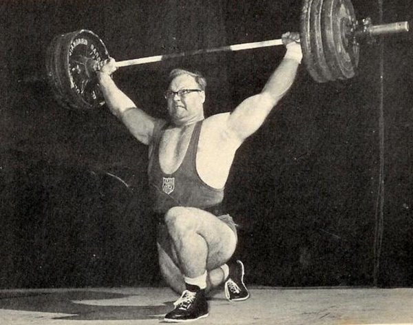 Ski was “the sophisticated brute,” fast as lighting on his split cleans and split snatches. Here he pulls 330—look at the balletic athletic poetry of this bottom position. He would whip the snatch bar to sternum height, then dive under the barbell in an eye-blink, attaining this precarious position at the low point. From here he would “recover” and stand erect. Ski snatched a 363-pound world record at age 38.